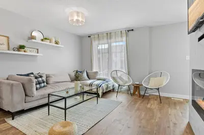 a living room with a couch and a table and chairs at Cozy Home - 9mins to WEM -Foosball -Vintage arcade - Air conditioning in Edmonton