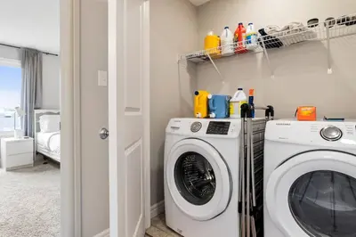 a laundry room with a washer and dryer at Cozy Home - 9mins to WEM -Foosball -Vintage arcade - Air conditioning in Edmonton