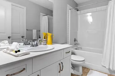 a white bathroom with a sink and a toilet at Cozy Home - 9mins to WEM -Foosball -Vintage arcade - Air conditioning in Edmonton