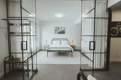 a bedroom with a bed and a glass wall at NYC Loft Inspired •12 mins to WEM •Vintage arcade in Edmonton