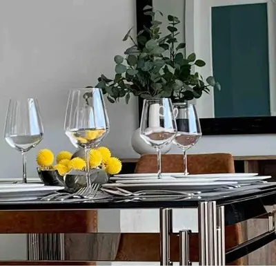 a table with three wine glasses and a vase with flowers at Beautiful 3Bed-with AC-Close to Spruce Meadows & Mountains in Calgary