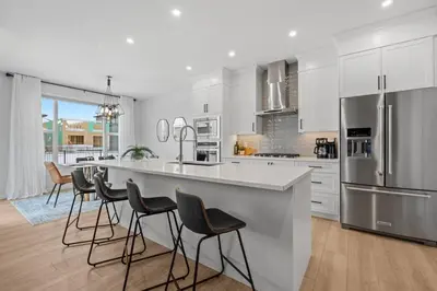 a kitchen with white cabinets and a large island with bar stools at Luxury-4bed with AC-86
