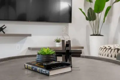 a table with a stack of books and a plant at Luxury-4bed with AC-86
