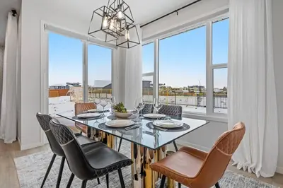 a dining room with a table and chairs and windows at Luxury-4bed with AC-86