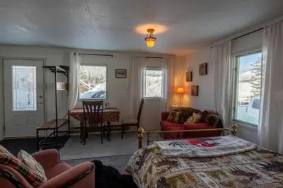 a bedroom with a bed and a living room at Meadow Suites in Wells in Barkerville
