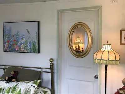 a bedroom with a mirror and a bed and a lamp at Meadow Suites in Wells in Barkerville