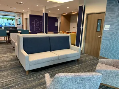 a couch in a waiting room with tables and chairs at Holiday Inn Express & Suites Courtenay - Comox by IHG in Courtenay