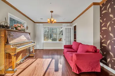 a living room with a red couch and a piano at Cozy Dunbar 3 Beds Home w/ Views in Vancouver