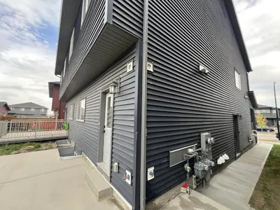 a black building with a fire hydrant next to it at Cozy New Suite in NW Calgary in Calgary