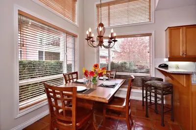 a dining room with a table and chairs and windows at Villas at Eldorado Resort in Kelowna