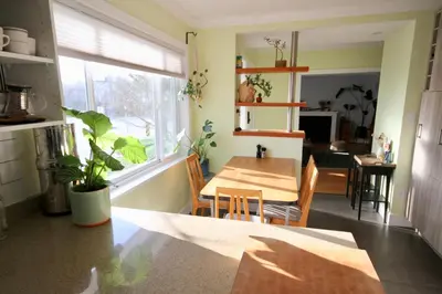 a kitchen and dining room with a table and a window at The Orange Door Bungalow- 2-BR w private yard, walkable to cafes & restaurants, 10 min to DT in Vancouver