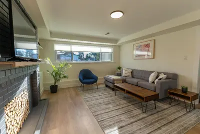 a living room with a couch and a fireplace at Guest Suite steps away from parks, trails & transit. in Port Coquitlam