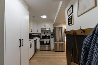 a kitchen with white cabinets and stainless steel appliances at Guest Suite steps away from parks, trails & transit. in Port Coquitlam