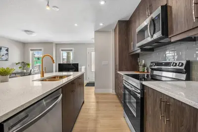 a kitchen with a sink and a stove at Stylish 3BR Townhouse by Airport in Calgary