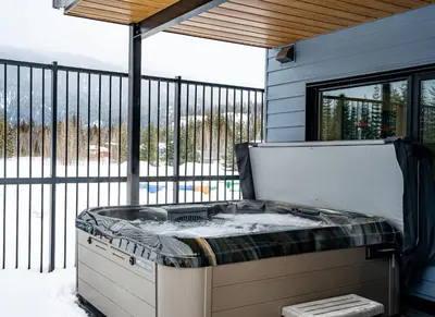 a hot tub sitting on a screened in porch at Switchback Suite by Revelstoke Vacations in Revelstoke