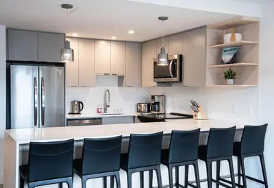 a kitchen with a large counter with blue chairs at Switchback Suite by Revelstoke Vacations in Revelstoke