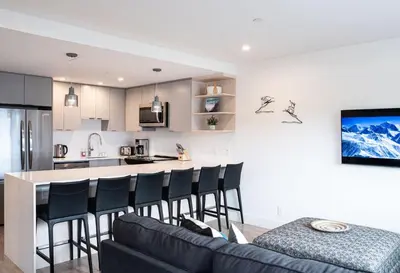 a kitchen and living room with a couch and a counter at Switchback Suite by Revelstoke Vacations in Revelstoke