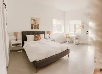 a white bedroom with a large bed and a sink at Drift West Coast Getaway in Ucluelet