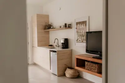 a small kitchen with a sink and a tv at Drift West Coast Getaway in Ucluelet