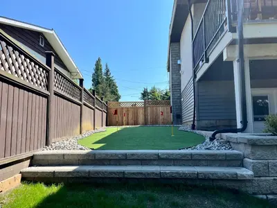 a miniature golf course in a yard next to a house at Brand New 2 Bedroom Suite in Langley Twp - Play Area, Patio & Mini Golf in Aldergrove