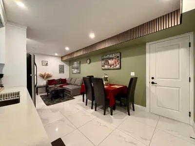 a dining room with a red table and black chairs at Brand New 2 Bedroom Suite in Langley Twp - Play Area, Patio & Mini Golf in Aldergrove