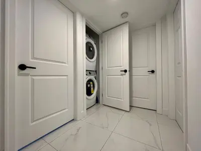 a white laundry room with two washing machines at Brand New 2 Bedroom Suite in Langley Twp - Play Area, Patio & Mini Golf in Aldergrove