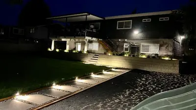 a house with lights in the front yard at night at Brand New 2 Bedroom Suite in Langley Twp - Play Area, Patio & Mini Golf in Aldergrove