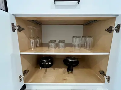 a cupboard filled with glasses and wine glasses at Brand New 2 Bedroom Suite in Langley Twp - Play Area, Patio & Mini Golf in Aldergrove