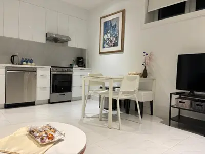 a kitchen with a table and chairs and a television at Fancy Family Suite with Parking near UBC in Vancouver