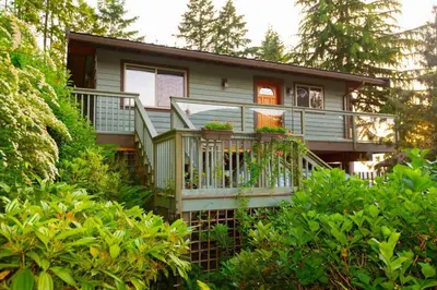 a house with a large deck with plants on it at Caboose in Bowen Island