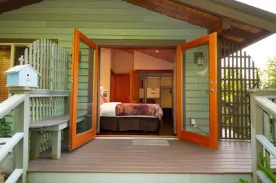 an open door to a bedroom with a bed on a porch at Caboose in Bowen Island