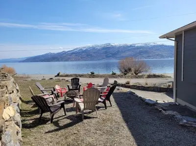 a group of chairs and tables with a view of a lake at Lakeview B&B in Peachland
