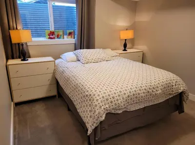 a bedroom with a bed with two night stands and two lamps at Lakeview B&B in Peachland
