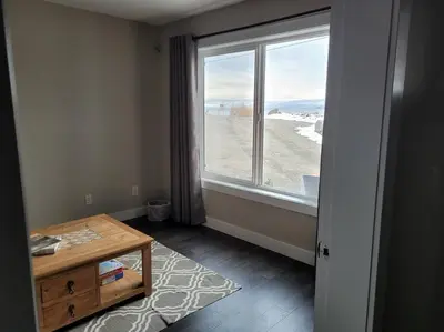 a room with a large window and a wooden table at Lakeview B&B in Peachland