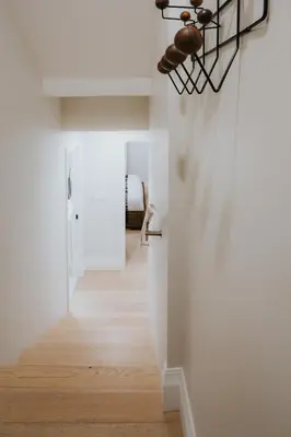 a hallway with white walls and wood floors and a ceiling at A Gentle Hideaway in the Urban Forest WEST END downtown Vancouver in Vancouver