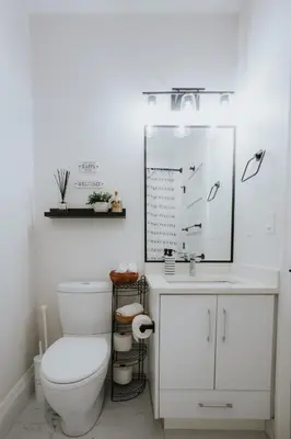 a white bathroom with a toilet and a sink at A Gentle Hideaway in the Urban Forest WEST END downtown Vancouver in Vancouver