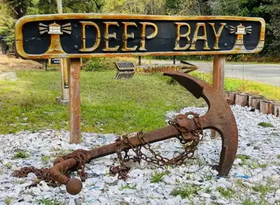 a sign that says deer bay with a chain at The Beach House at Deep Bay in Bowser