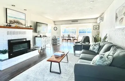 a living room with a couch and a tv at The Beach House at Deep Bay in Bowser