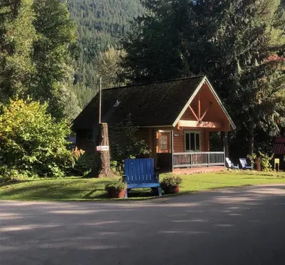 a blue bench sitting in front of a house at Revelstoke RV & Cabin Resort in Revelstoke