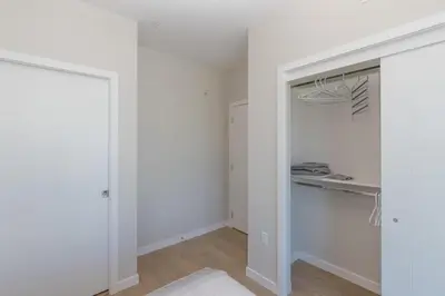 a white room with a closet and a door at Live The Dream In The Haro in Saanichton