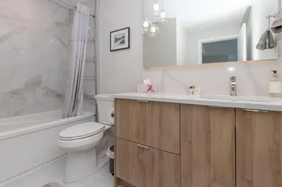 a bathroom with a toilet and a sink and a tub at Live The Dream In The Haro in Saanichton