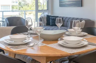 a wooden table with plates and wine glasses on it at Live The Dream In The Haro in Saanichton