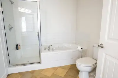 a white bathroom with a tub and a toilet at The Beach House at Barona Beach 4301 in West Kelowna