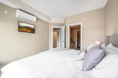 a bedroom with a bed with white sheets and pillows at Top Floor Apartment at Amenity Rich Resort 406 in West Kelowna