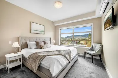 a bedroom with a large bed and a window at Top Floor Apartment at Amenity Rich Resort 406 in West Kelowna