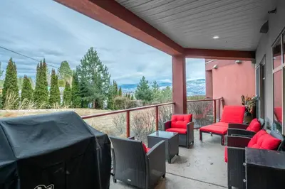 a porch with chairs and red cushions on a balcony at Fabulous Condo at Five Star Resort 209 in West Kelowna