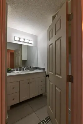 a bathroom with a sink and a large mirror at Bowness Suites in Calgary