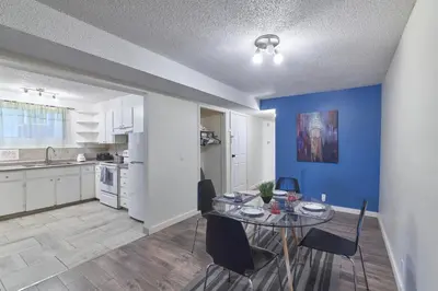 a kitchen and dining room with a table and chairs at Bowness Suites in Calgary