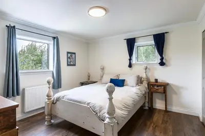 a bedroom with a white bed and two windows at Yukon River Farm in Whitehorse