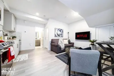 a kitchen and a living room with a couch at *NEW* Modern Suite King Bed! Netflix! Sleeps 4! in Edmonton